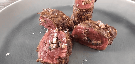 Bavette roulée aux champignons dressée sur une assiette